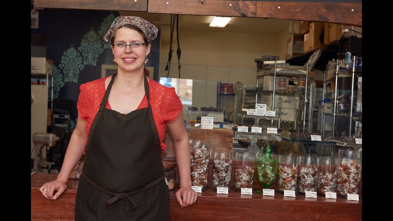 Local woman-owned bakery owner posing at store front