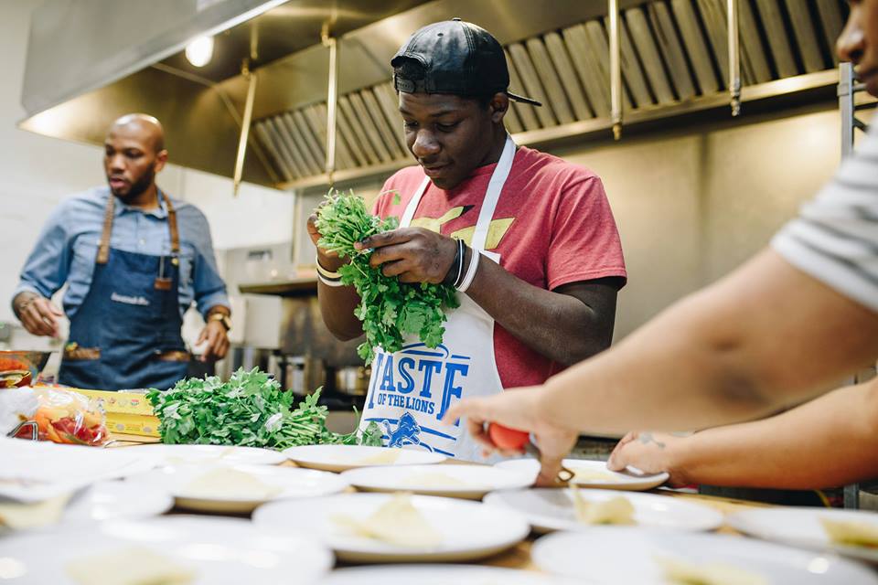 Young adults from Detroit Food Academy cooking. Packed with Purpose, Impact Partners.