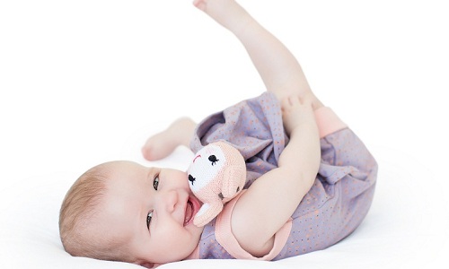 Newborn baby girl playing with toy.