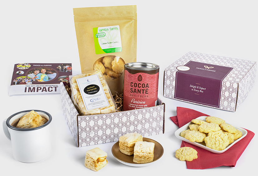 Hot chocolate themed gift box, surrounded by gourmet marshmallows, cookies, and a mug