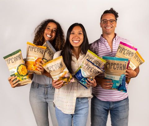 Founders of Pipcorn holding their product. A Packed with Purpose Impact Partners.