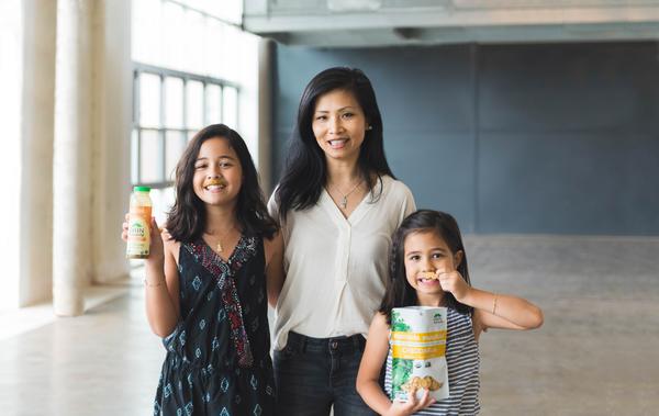 Founder of VanTrang Manges and her kids holding Green Mustache products