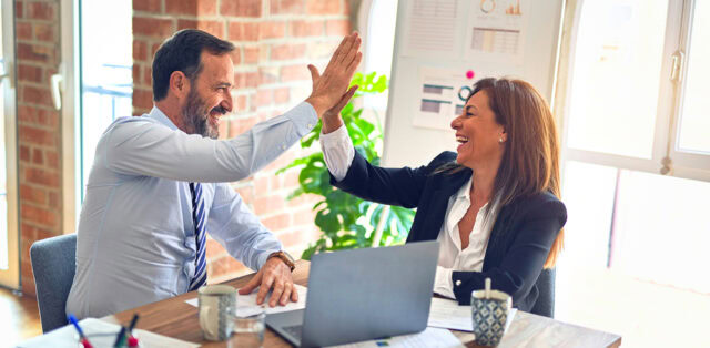 Co-workers high fiving