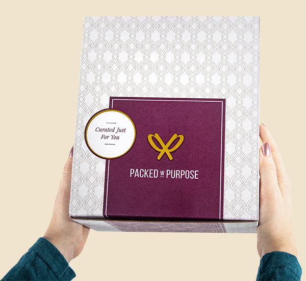 Employee holding a Packed with Purpose gift box