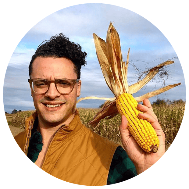 Smiling man with heirloom corn in a field