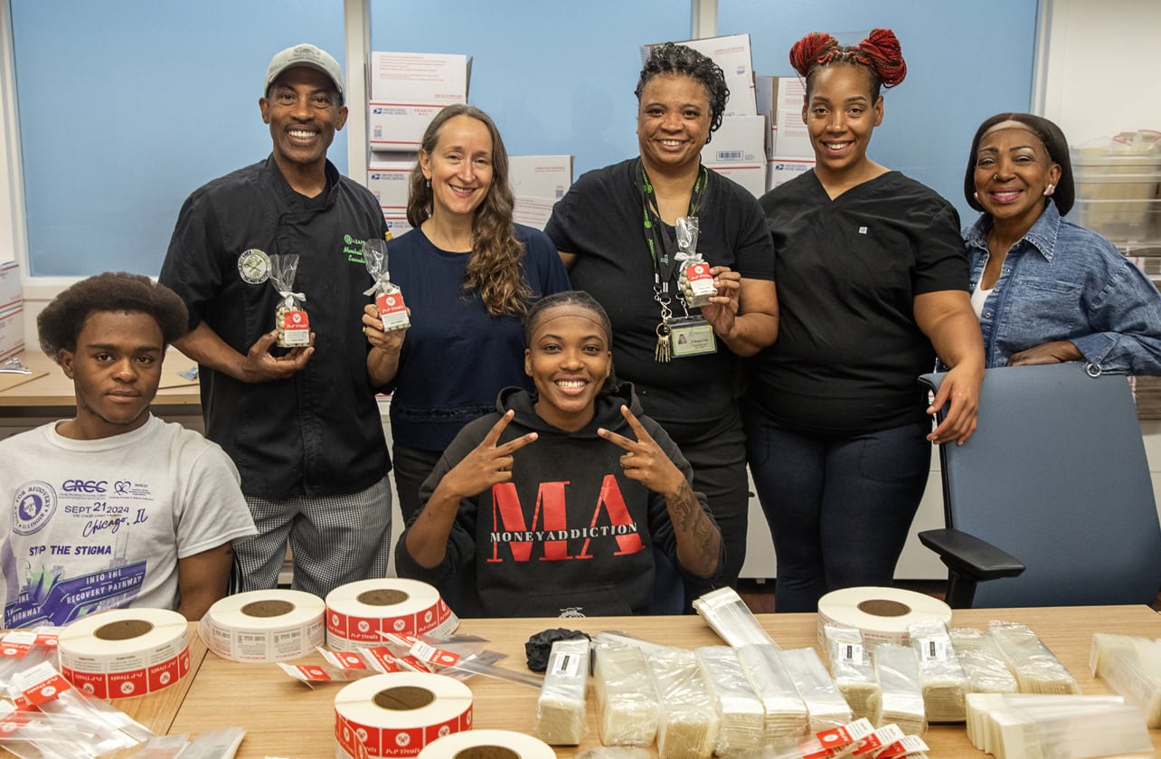 Participants of A Safe Haven program showing off their PwP Treats products