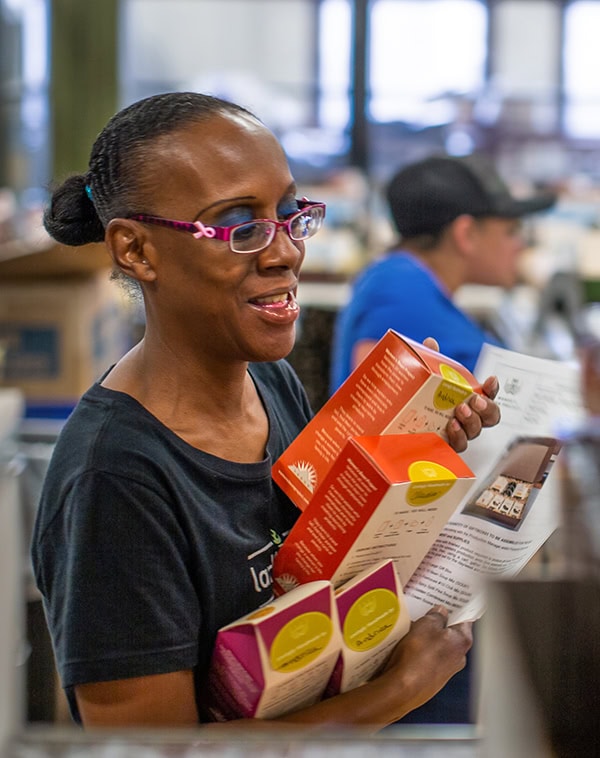 Woman assembling packaging at Women's Bean Project warehouse