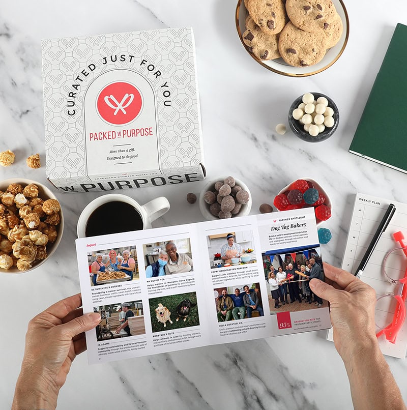 Hands leafing through a booklet depicting the stories associated with a gift
