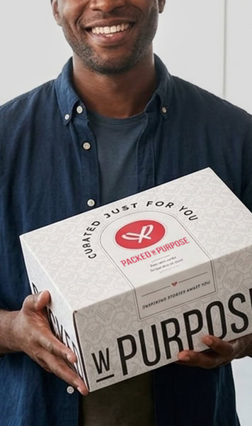 Male employee smiling while holding a gift box