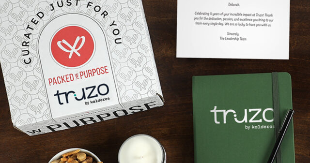 A branded gift box, notebook, candle, and personalized message card