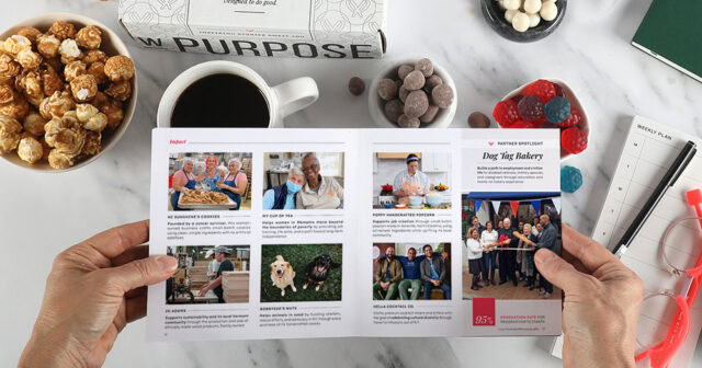 Hands holding open an impact booklet over a gift spread across a desktop