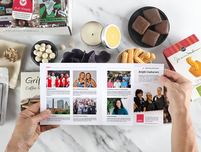 Hands holding open a booklet over a bountiful gift